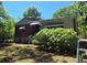 View of house with brick and siding, overgrown bushes, with a partly cloudy sky at 25 Candler Se Rd, Atlanta, GA 30317