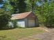 View of a detached single-car garage with a white door and mature landscaping at 25 Candler Se Rd, Atlanta, GA 30317