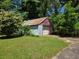 View of a detached single-car garage with a white door and mature landscaping at 25 Candler Se Rd, Atlanta, GA 30317