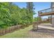 Landscaped backyard with a wooden deck and tree line at 7820 Bristol Valley Dr, Cumming, GA 30028