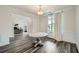 Elegant dining room featuring wood-look floors, white wainscoting, and a view into the home office at 7820 Bristol Valley Dr, Cumming, GA 30028