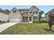 Charming two-story home with white brick, dark shutters, and a well-manicured front yard at 7820 Bristol Valley Dr, Cumming, GA 30028