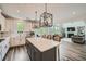 Open-concept kitchen featuring a large island, stainless steel appliances, and seamless flow to the living area at 7820 Bristol Valley Dr, Cumming, GA 30028