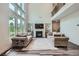 Bright living room boasts a fireplace, hardwood flooring, a soaring ceiling, and large windows at 7820 Bristol Valley Dr, Cumming, GA 30028