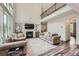 Spacious living room with soaring ceilings and a fireplace; hardwood flooring; natural light from large windows at 7820 Bristol Valley Dr, Cumming, GA 30028