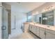 Bright primary bathroom with double sinks, a glass-enclosed shower, and a separate soaking tub at 7820 Bristol Valley Dr, Cumming, GA 30028