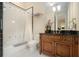 Bathroom featuring tiled floor, bath tub with shower, wooden vanity, and neutral walls, offers a calming space at 927 Berkshire Ne Rd, Atlanta, GA 30324