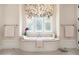 Elegant bathroom features a soaking tub with decorative window and tile flooring at 927 Berkshire Ne Rd, Atlanta, GA 30324