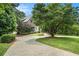 Exterior view showing a large circular driveway and lush landscaping around this beautiful brick Tudor home at 927 Berkshire Ne Rd, Atlanta, GA 30324