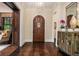 Entry foyer with herringbone wood floors, decorative cabinet, and a view of the paneled living room at 927 Berkshire Ne Rd, Atlanta, GA 30324
