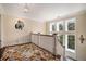 Bright hallway with natural light, featuring hardwood floors, a colorful rug, and elegant white railings at 927 Berkshire Ne Rd, Atlanta, GA 30324