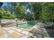 Stunning pool area with a stone patio, lush landscaping, and comfortable lounge chairs at 927 Berkshire Ne Rd, Atlanta, GA 30324