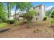 A beige two-story home boasts a spacious backyard with a wooden deck overlooking the lush green landscape at 1010 Graystone Xing, Alpharetta, GA 30005
