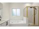 Well-lit bathroom showcases a bathtub and a shower with a gold-trimmed glass enclosure at 1010 Graystone Xing, Alpharetta, GA 30005