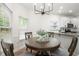 Inviting dining area with natural light, wood table, and modern chandelier adjacent to the kitchen at 1010 Graystone Xing, Alpharetta, GA 30005