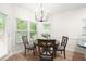 Bright dining area features wood table, four chairs, large windows and a modern chandelier at 1010 Graystone Xing, Alpharetta, GA 30005