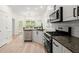 Modern kitchen with stainless steel appliances, white cabinets, and granite countertops at 1010 Graystone Xing, Alpharetta, GA 30005