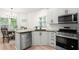Well-lit kitchen with stainless steel appliances, white cabinets, and hardwood floors next to a dining area at 1010 Graystone Xing, Alpharetta, GA 30005