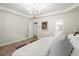 Serene main bedroom with light walls, wood floor, chandelier, and ensuite bathroom access at 1010 Graystone Xing, Alpharetta, GA 30005