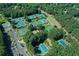 Aerial view of community tennis courts surrounded by mature trees and ample parking space at 1010 Graystone Xing, Alpharetta, GA 30005