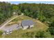 Aerial view of a home surrounded by lush trees, featuring ample parking and a spacious yard at 212 Postell Rd, Dallas, GA 30157