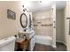 Well-lit bathroom featuring a shower-tub combination with tile surround, vanity, and essential fixtures for comfort at 212 Postell Rd, Dallas, GA 30157