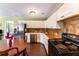 An open kitchen featuring white cabinets and stainless steel appliances with wood floors at 212 Postell Rd, Dallas, GA 30157