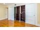 Bedroom has hardwood flooring, access to additional storage, closet, and is painted with warm tones at 3091 Colonial Way # I2, Atlanta, GA 30341