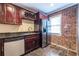 Compact kitchenette featuring stainless steel appliances, granite countertops, and a brick accent wall at 3091 Colonial Way # I2, Atlanta, GA 30341