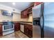 Kitchenette with stainless steel appliances, dark cabinetry, tile flooring, and granite countertops at 3091 Colonial Way # I2, Atlanta, GA 30341