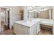 Bright bathroom features a vanity with double sinks, large mirrors, and shower with decorative tile at 4217 Wieuca Overlook Ne, Atlanta, GA 30342