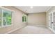 Bedroom with wall to wall carpeting, two windows, and french doors with nature views at 4217 Wieuca Overlook Ne, Atlanta, GA 30342