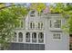 Multi-level gray home with bright white trim and balconies, surrounded by mature trees at 4217 Wieuca Overlook Ne, Atlanta, GA 30342