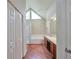 Bathroom boasting wood-look floors, granite counters, and a triangle window above the tub at 616 Lone Oak Ct, Lithonia, GA 30058