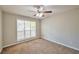 Bedroom featuring a large window that provides natural light, plush carpet, and neutral walls for a calming atmosphere at 616 Lone Oak Ct, Lithonia, GA 30058