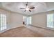 Spacious main bedroom with carpet floors, a ceiling fan, and bright windows at 616 Lone Oak Ct, Lithonia, GA 30058