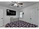 Bedroom featuring a comfy bed, a large television, and neutral-colored walls at 1358 Millstream Trl, Lawrenceville, GA 30044