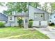 Charming gray home featuring a two-car garage, beautiful landscaping, and a welcoming front entrance at 1358 Millstream Trl, Lawrenceville, GA 30044