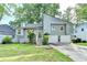 Charming gray home featuring a two-car garage, beautiful landscaping, and a welcoming front entrance at 1358 Millstream Trl, Lawrenceville, GA 30044
