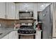 Close-up view of modern gas range and stainless refrigerator in stylish kitchen at 1358 Millstream Trl, Lawrenceville, GA 30044