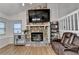 Cozy living room with stone fireplace, hardwood floors, and ample natural light at 1358 Millstream Trl, Lawrenceville, GA 30044