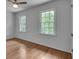 Bright bedroom featuring hardwood floors, two windows providing natural light, and a ceiling fan at 2592 River Oak Dr, Decatur, GA 30033