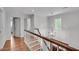 Upstairs hallway features wood floors, decorative lighting and white wood trim and wainscoting at 2592 River Oak Dr, Decatur, GA 30033
