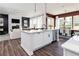 Open-concept kitchen features an island, white cabinetry, flows into the living area and dining space at 417 Newland Way, Acworth, GA 30102