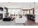Open-concept living room with modern decor, fireplace, large windows, and seamless flow to kitchen at 417 Newland Way, Acworth, GA 30102