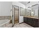 This gorgeous bathroom boasts a soaking tub, glass-enclosed shower, double sink vanity, and unique decorative glass block features at 475 Shadetree Ln, Lawrenceville, GA 30044