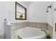 This bathroom features a corner soaking tub, a window for natural light, and neutral tiling around the tub at 475 Shadetree Ln, Lawrenceville, GA 30044