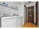 This practical laundry room is equipped with a washer and dryer, shelving for storage, and a door for easy access at 475 Shadetree Ln, Lawrenceville, GA 30044