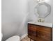Stylish half bathroom featuring an octagonal mirror and a modern vanity with marble countertop at 600 Oakmont Hl, Duluth, GA 30097