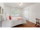 Well-lit bedroom featuring hardwood floors, a window with shutters, and a comfortable bed at 739 Dushea Nw Ct, Kennesaw, GA 30144
